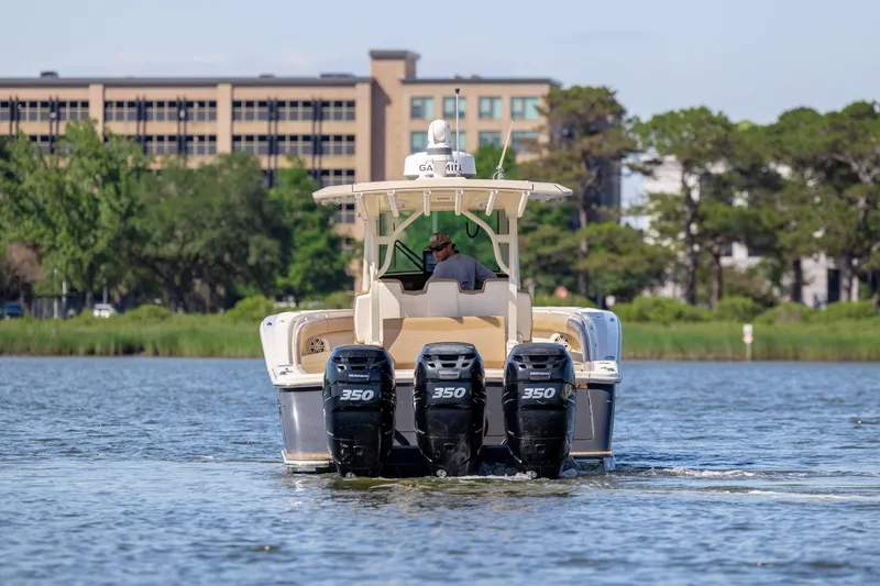 Slide: The Image of 2019 Scout 355 LXF boat with triple 350 engines cruising on a calm river. - 3