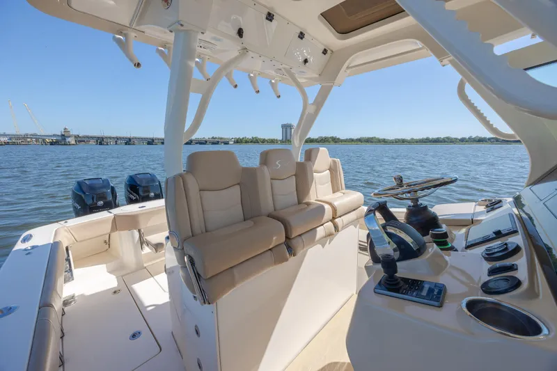 Slide: The Image of 2019 Scout 355 LXF boat interior with helm, seating, and dual engines on water. - 23