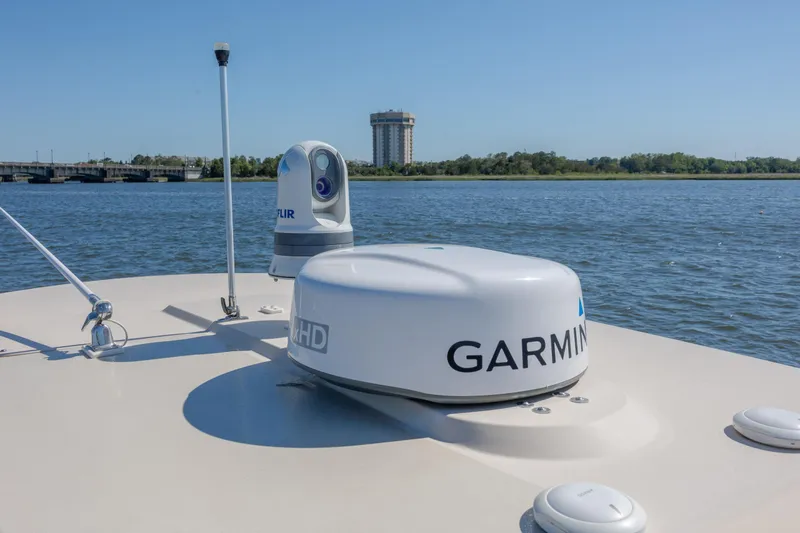 Slide: The Image of 2019 Scout 355 LXF boat with Garmin radar on calm water, bridge and tower in background. - 34