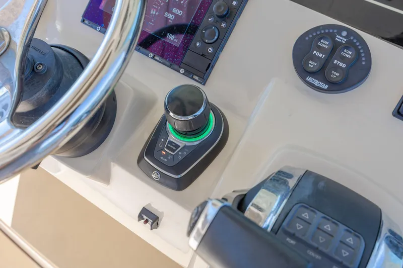 Slide: The Image of Control panel of a 2019 Scout 355 LXF boat with steering wheel and navigation controls. - 26