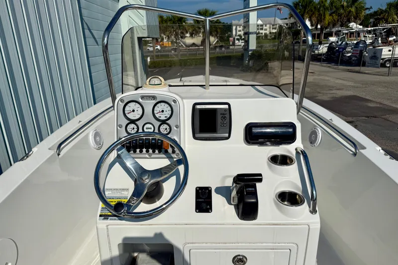 Slide: The Image of 2012 Sea Hunt Triton 210 boat dashboard with steering wheel, gauges, and controls. - 6