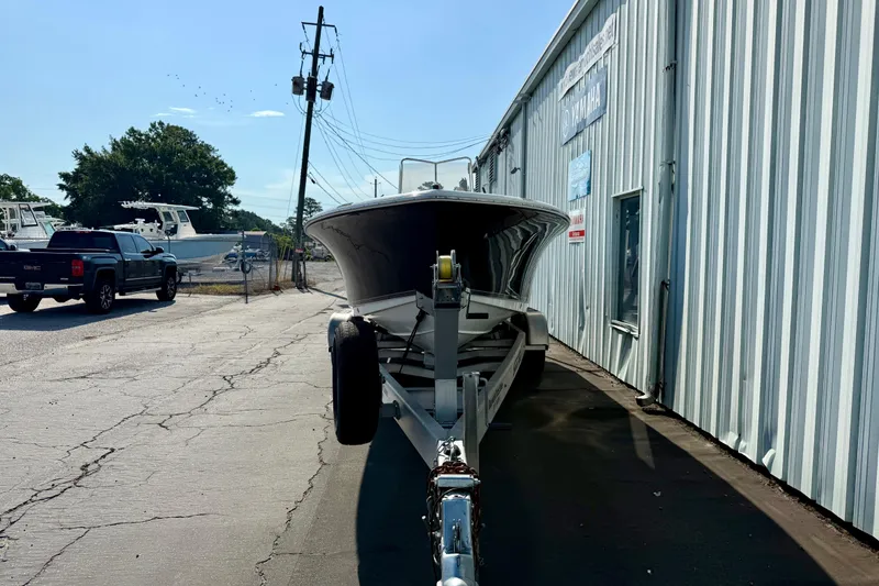 Slide: The Image of 2012 Sea Hunt Triton 210 boat on trailer beside a metal building. - 5
