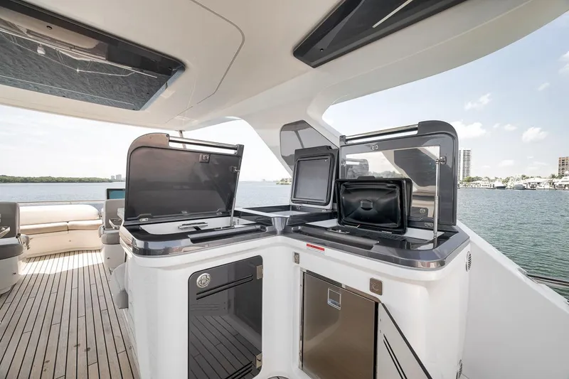 Slide: The Image of Luxurious 2022 Galeon 560 Fly yacht deck with modern outdoor kitchen and scenic waterfront view. - 83
