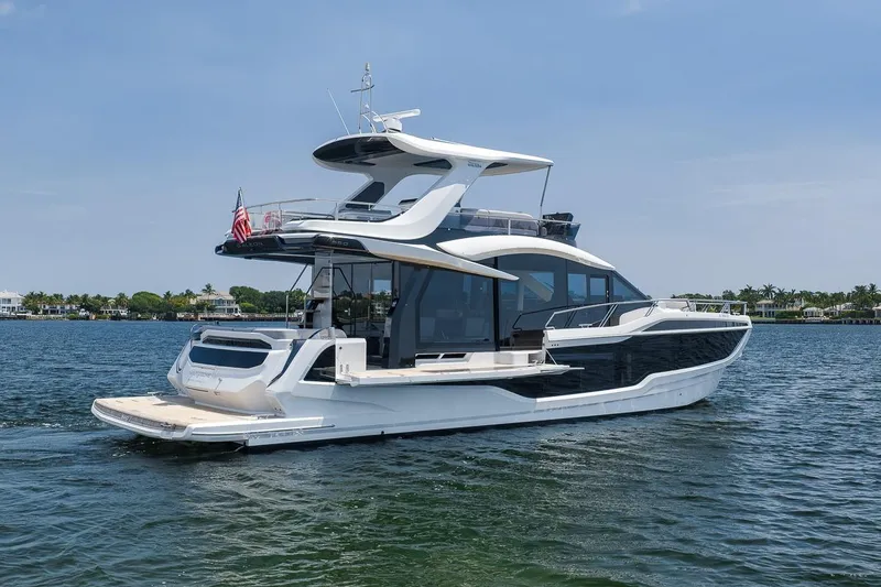 Slide: The Image of Luxury 2022 Galeon 560 Fly yacht cruising on calm waters under a clear sky. - 9