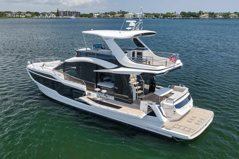 Slide: The Image of 2022 Galeon 560 Fly yacht cruising on calm waters, showcasing sleek design and luxury features. - 16