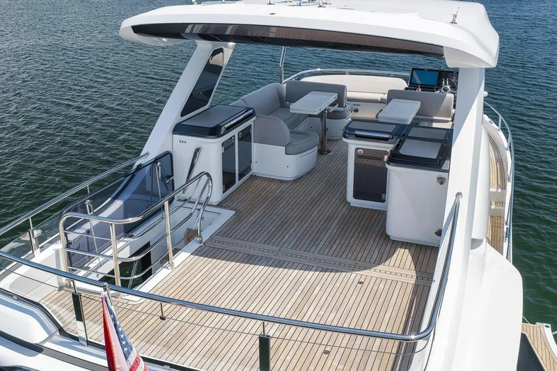 Slide: The Image of Luxury Galeon 560 Fly yacht deck, 2022 model, featuring elegant seating and dining area on water. - 19