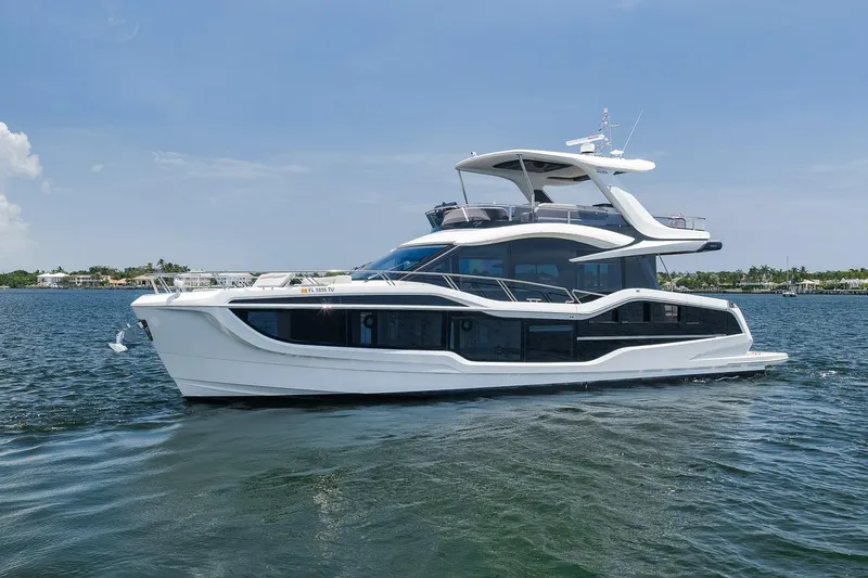 Slide: The Image of 2022 Galeon 560 Fly yacht cruising on calm waters under a clear blue sky. - 15