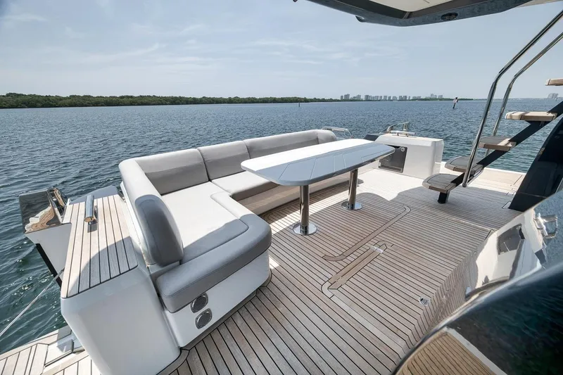 Slide: The Image of Luxurious 2022 Galeon 560 Fly yacht deck with elegant seating and scenic water view. - 91