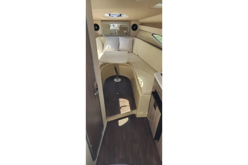 Slide: The Image of Interior of a 2006 Doral Elegante boat with beige seating and a small table. - 13