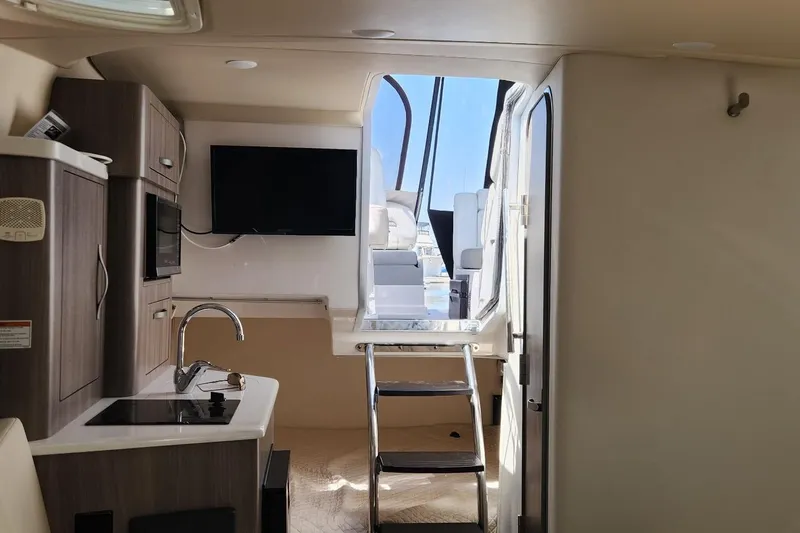 Slide: The Image of Interior of 2006 Doral Elegante yacht with kitchenette, TV, and stairs leading outside. - 12