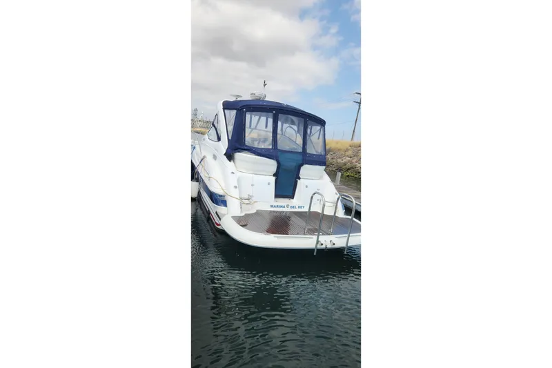 Slide: The Image of 2006 Doral Elegante boat docked at Marina del Rey, featuring a blue canopy. - 1