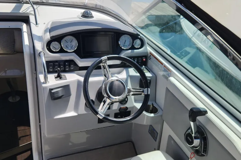 Slide: The Image of Cockpit of a 2006 Doral Elegante boat featuring steering wheel and control panel. - 15