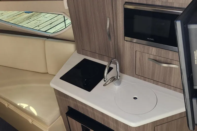 Slide: The Image of 2006 Doral Elegante interior with kitchenette, featuring sink, stove, and microwave. - 14