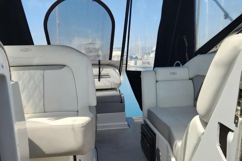Slide: The Image of Interior of a 2006 Doral Elegante boat with white leather seating and marina view. - 11