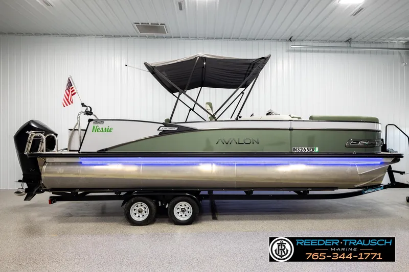 Slide: The Image of 2024 Avalon CAT VRB pontoon boat with canopy and American flag in a showroom. - 5