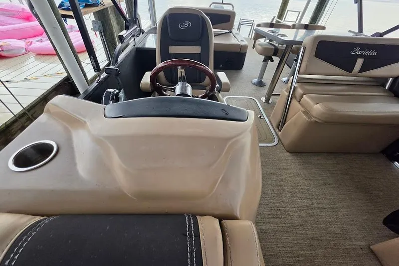 Slide: The Image of Interior of a 2022 Barletta Cabrio 24UE pontoon boat with beige seating and steering wheel. - 17