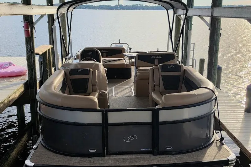 Slide: The Image of 2022 Barletta Cabrio 24UE pontoon boat docked, featuring spacious seating and elegant design. - 4