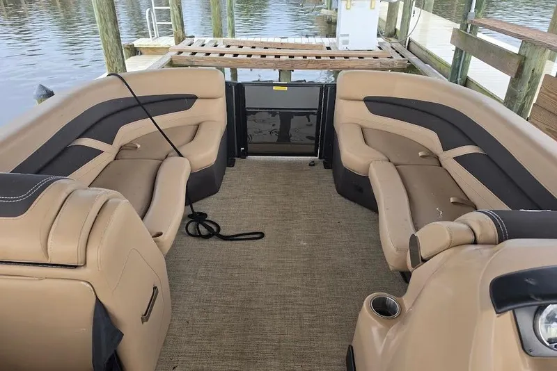Slide: The Image of 2022 Barletta Cabrio 24UE pontoon boat interior with tan seating and carpeted floor. - 10