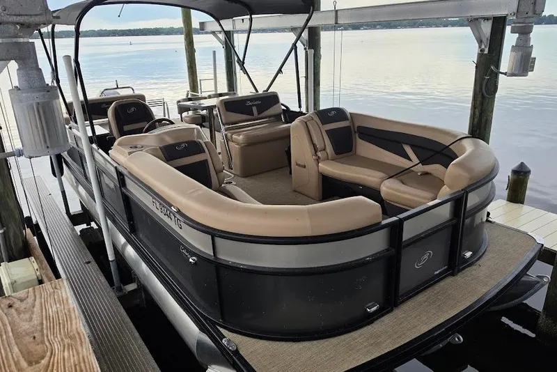 Slide: The Image of 2022 Barletta Cabrio 24UE pontoon boat docked on a serene lake. - 3