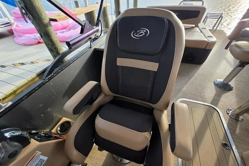 Slide: The Image of Captain's chair on 2022 Barletta Cabrio 24UE pontoon boat, dockside view. - 14
