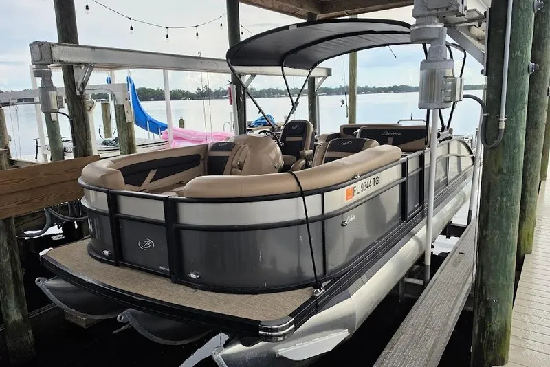 The Image of 2022 Barletta Cabrio 24UE pontoon boat docked under a covered pier. - 1