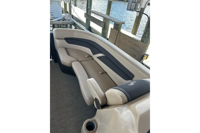 Slide: The Image of 2022 Barletta Cabrio 24UE boat interior with beige and black seating by the dock. - 42