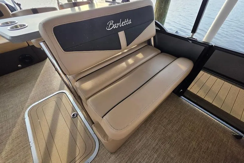 Slide: The Image of Barletta Cabrio 24UE 2022 boat interior with beige seating and cup holders. - 21