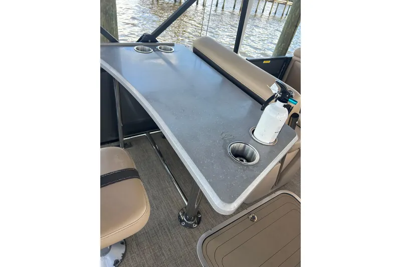 Slide: The Image of Barletta Cabrio 24UE 2022 boat interior with table, cup holders, and fire extinguisher. - 33