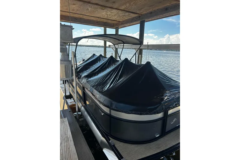 Slide: The Image of 2022 Barletta Cabrio 24UE pontoon boat covered at dockside. - 1