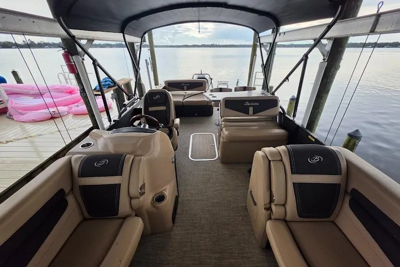 Slide: The Image of 2022 Barletta Cabrio 24UE pontoon boat interior with plush seating and lake view. - 7