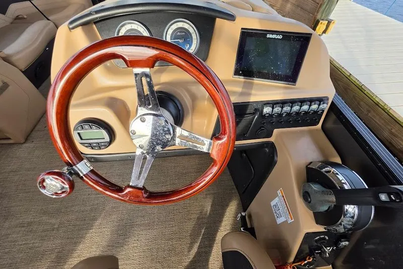 Slide: The Image of Steering console of 2022 Barletta Cabrio 24UE with wood finish and modern controls. - 11