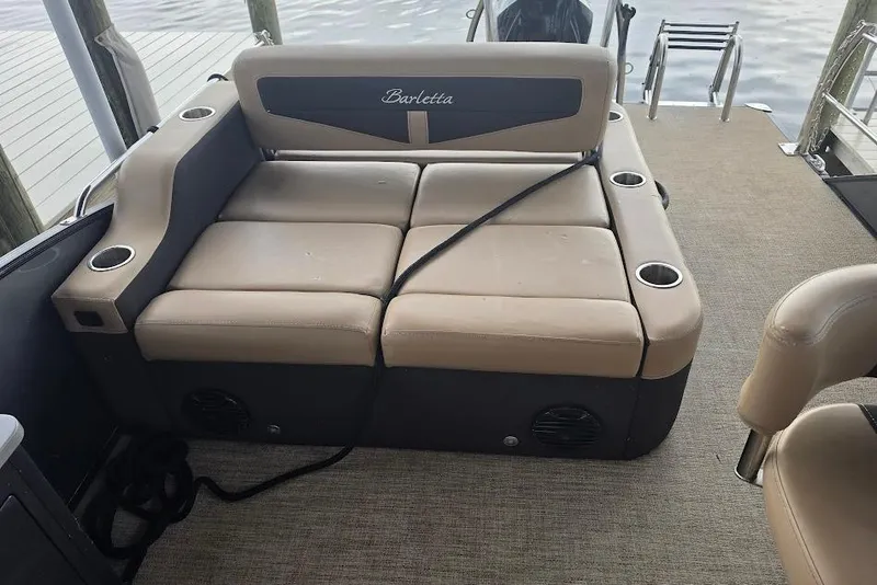 Slide: The Image of Barletta Cabrio 24UE 2022 boat interior with beige seating and cup holders. - 18