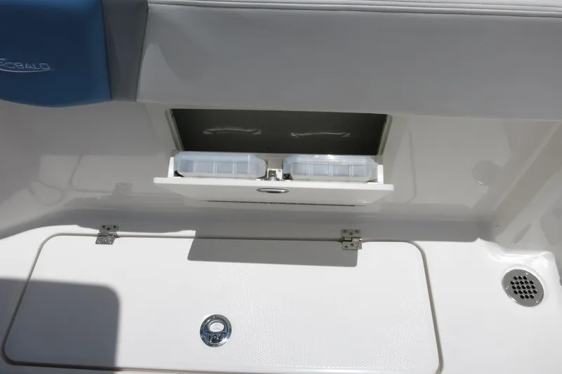 Slide: The Image of 2026 Robalo R250 Center Console storage compartment with tackle boxes and seating. - 24