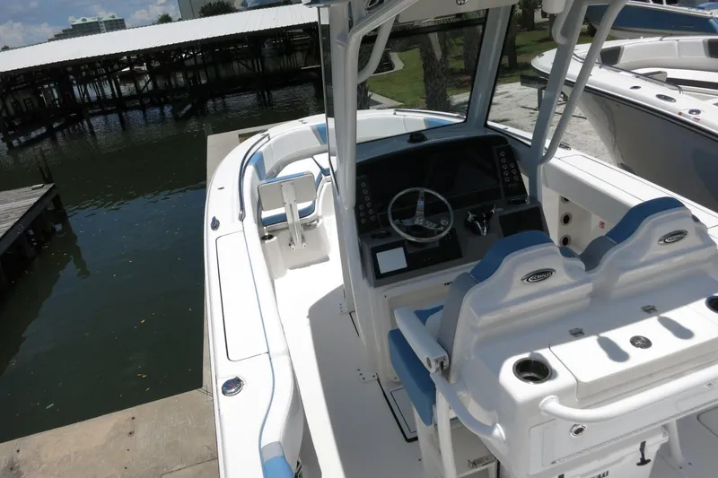 Slide: The Image of 2026 Robalo R250 Center Console boat with sleek design and modern controls at a dock. - 14