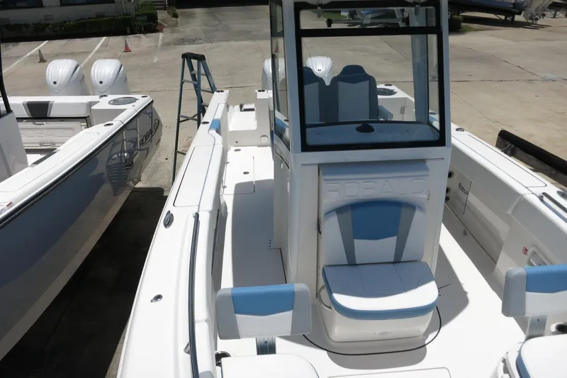 Slide: The Image of 2026 Robalo R250 Center Console boat with dual engines, docked in a marina. - 34