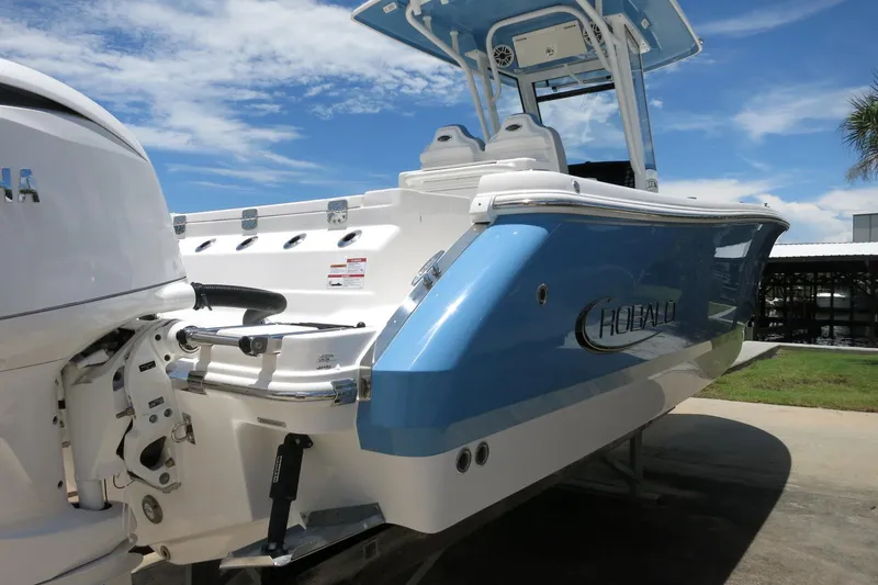 Slide: The Image of 2026 Robalo R250 Center Console boat with blue and white exterior, docked under a clear sky. - 6