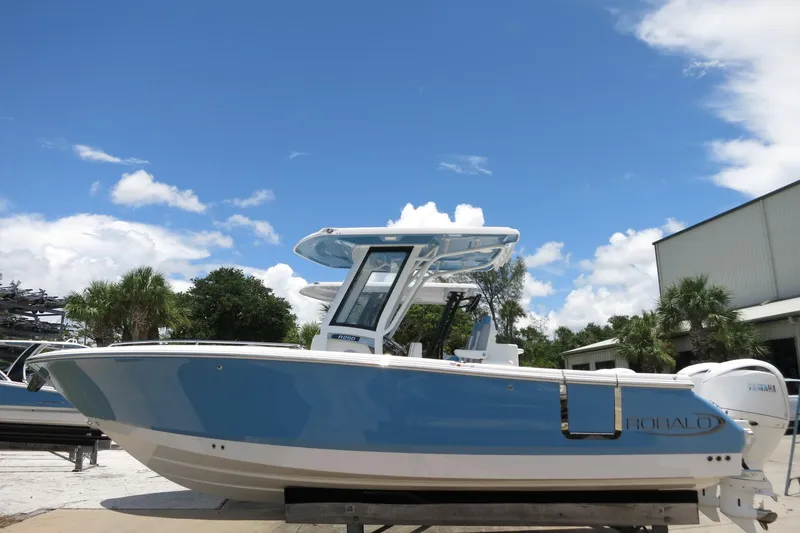 The Image of 2026 Robalo R250 Center Console boat in a marina setting under a clear blue sky. - 0