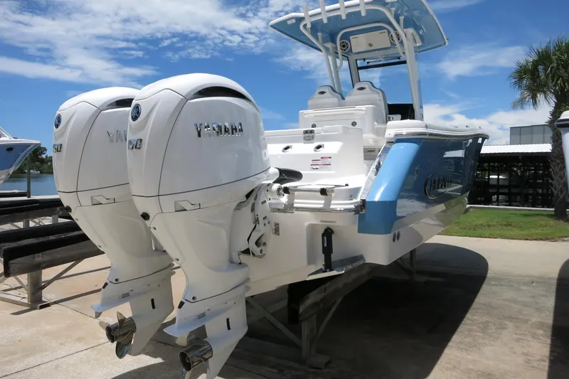 Slide: The Image of 2026 Robalo R250 Center Console boat with dual Yamaha engines, docked under a clear sky. - 5