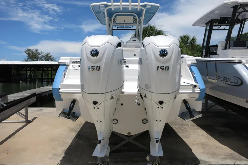 Slide: The Image of 2026 Robalo R250 Center Console boat with dual Yamaha 150 engines docked. - 9