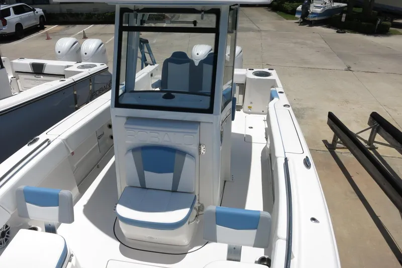 Slide: The Image of 2026 Robalo R250 Center Console boat with blue and white seating, docked outdoors. - 33
