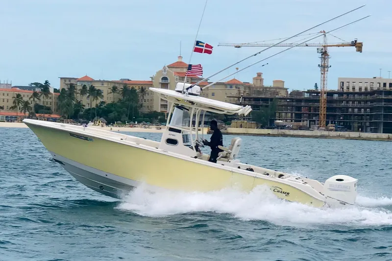 Slide: The Image of 2018 Sea Chaser 27 HFC CC boat cruising near coastal buildings and cranes. - 2