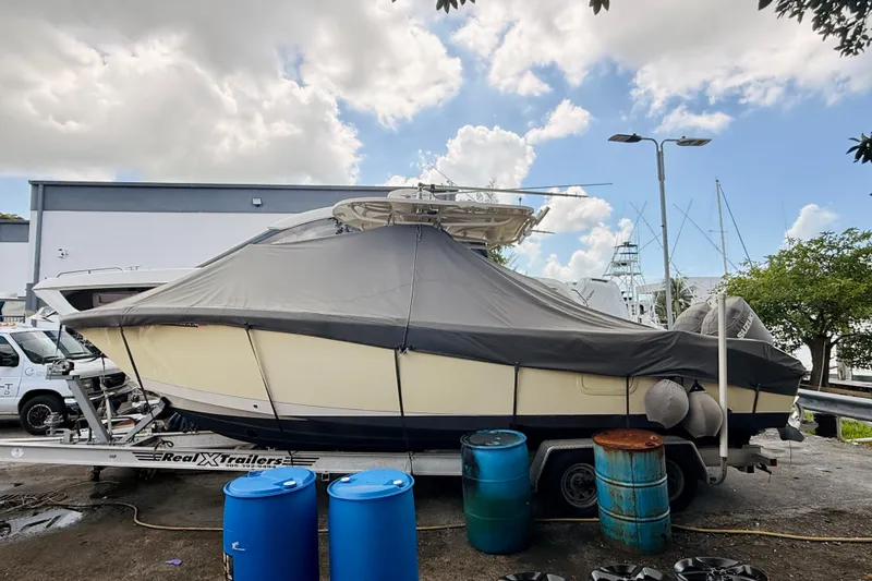 Slide: The Image of 2018 Sea Chaser 27 HFC CC boat covered on trailer, parked outdoors under cloudy sky. - 4