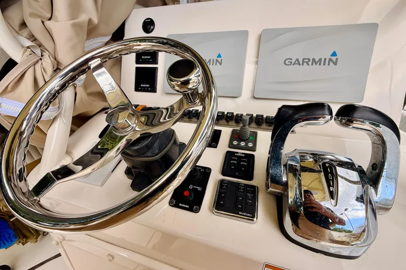 Slide: The Image of 2018 Sea Chaser 27 HFC CC helm with Garmin displays and chrome steering wheel. - 29
