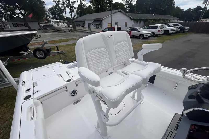 Slide: The Image of 2027 Tidewater 2500 Carolina Bay boat with white seating and steering console. - 11