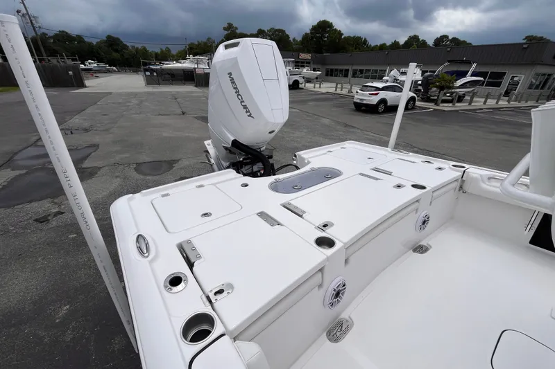 Slide: The Image of 2027 Tidewater 2500 Carolina Bay boat with Mercury engine, parked outdoors under cloudy skies. - 5
