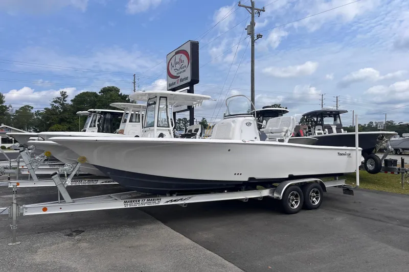 The Image of 2027 Tidewater 2500 Carolina Bay boat on trailer at dealership, clear sky background. - 0