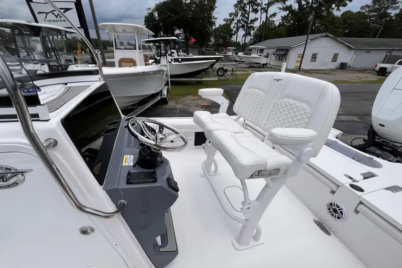Slide: The Image of 2027 Tidewater 2500 Carolina Bay boat interior with steering console and white seating. - 13