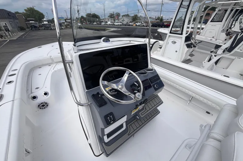 Slide: The Image of 2027 Tidewater 2500 Carolina Bay boat dashboard with steering wheel and controls. - 6