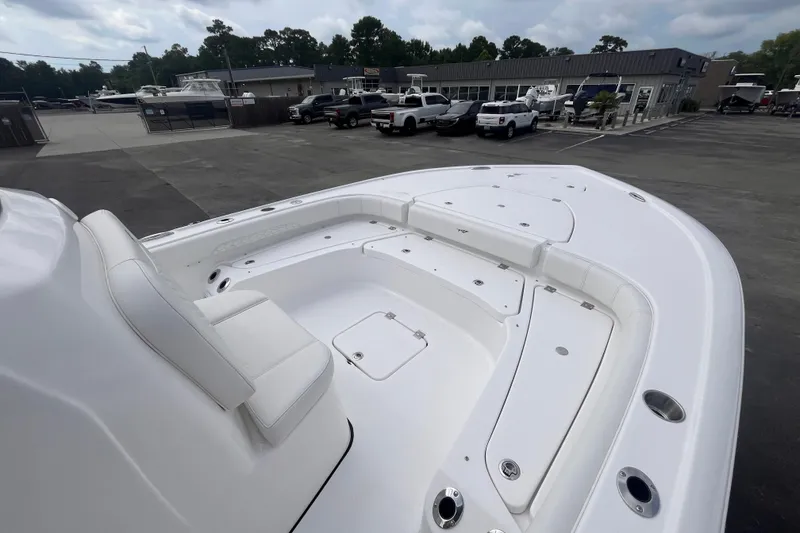 Slide: The Image of 2027 Tidewater 2500 Carolina Bay boat with spacious deck and seating, parked in a marina. - 9