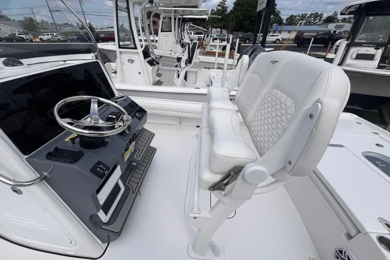 Slide: The Image of 2027 Tidewater 2500 Carolina Bay boat interior with steering console and cushioned seating. - 5
